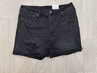 Front view of washed-black ripped mom jean shorts