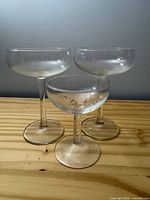 Three coupe glasses standing on wooden surface