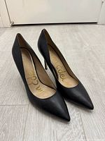 Side view of both black leather Sam Edelman heels showing pointed toes and stiletto heels