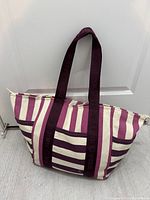 Front view of striped tote showing pocket and handles