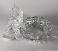 Square and round clear glass ashtrays side by side
