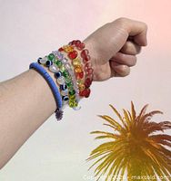 Selection of bracelets on wrist showing gummy bear, evil eye and multicolour bead styles