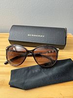 Front view of Burberry sunglasses with case and cloth