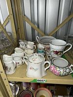 Group shot of all 14 bone-china creamers on shelf