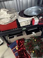 Shelving with stacked charger plates, boxed and bagged décor items