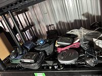 Shelf holding multiple portable CD players in cases, headphones and accessories