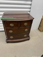 Full view of mahogany nightstand front showing drawers and brass-tone pulls