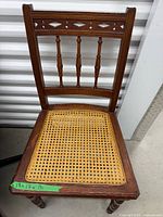 Full view of mahogany chair with cane seat and decorative backrest