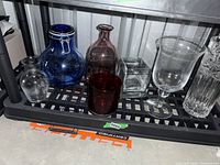 Shelf with seven assorted glass and crystal vases