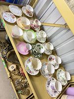 Shelf view showing six tea-cup and saucer duos and dessert plate