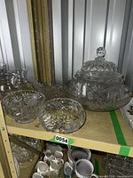 shelf view showing large lidded crystal bowl, two bowls and other crystal pieces