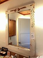 Full view of mirror mounted on wall showing entire frame and reflective surface