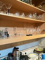 Full view of three cabinet shelves showing majority of glassware