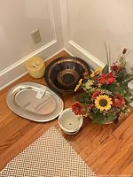 Group shot of all items: metal tray, decorative bowl, planter, candle, floral arrangement
