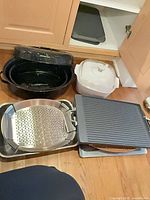Group showing enamel roaster, ceramic casserole, stainless pan with rack and grill pan
