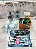 Group shot showing all toiletries including toothbrush packs, brush heads, razors, colognes