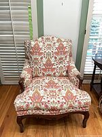 Front view of armchair showing upholstery pattern and wood frame