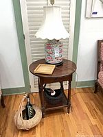 Full view of side table with lamp on top and lower shelf visible