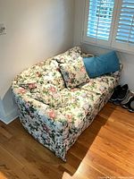 Loveseat with pillows in corner view