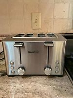 Front view of Geek Chef stainless steel 4-slice toaster showing controls and logo