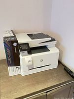 Overall view of HP Color LaserJet Pro MFP M281fdw printer with toner box on top