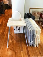 High chair assembled beside stacked play yard panels