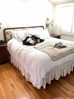 Full view of assembled king bed with bedding showing wood frame and floral headboard