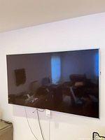 Front view of wall-mounted LG 65-inch TV powered off
