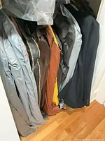 Row of garment-bagged coats and jackets in closet