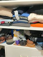 Top shelf with folded sweaters and scarf