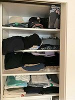 Shelf with boxed rain jacket, folded clothing, packaged shirts