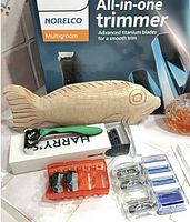 Group shot showing trimmer box, wooden fish, razor accessories and glass bottle