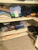 Stacks of folded men’s shirts, polos and sweaters on shelving