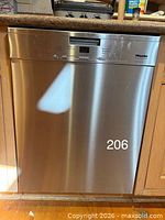 Front view of stainless Miele dishwasher installed in cabinetry