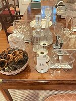 Group shot of glassware, candlesticks, mirrored tray and curtain hardware on dining table