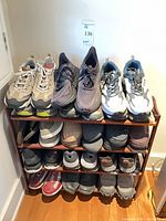 Full shoe rack showing 4 pairs on top shelf, 4 on middle, 2 on bottom