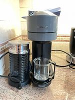 Vertuo Next machine with Aeroccino frother and glass cup on countertop