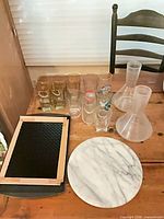 Overview of all glassware, decanters, cheese board, bar mat, tray on table