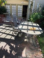 Entire patio dining set showing table shape, leg style and six matching chairs
