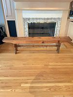 Full view of wooden bench in front of fireplace
