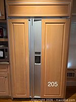 Front view of closed refrigerator with wood panel doors