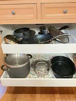Both drawers open showing entire assortment of pots and pans