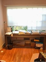 Front view of desk under window with lamp at left side