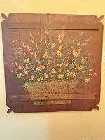 Full view square wooden plaque on wall showing floral painting