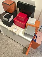 Group of assorted luxury brand boxes on cabinet
