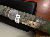 Rolled, wrapped rug with label and barcode visible