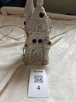 front view showing ceramic house, colored jewels, cord