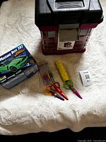 Lot overview showing model kit box, organizer toolbox, scissors, pens, cord