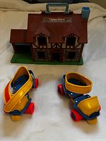 Dollhouse front and pair of skates on white background