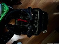 Top view of folded Graco Pack 'n Play showing plaid lining and red pull strap